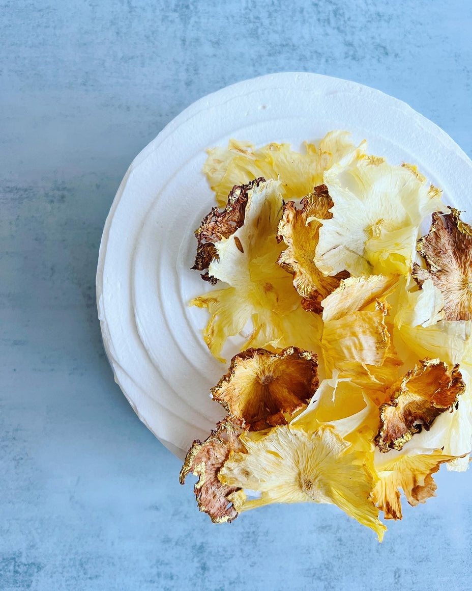 Custom cakes Honolulu by an italian pastry chef. This cake is a pineapple chiffon cake. It is made of vanilla sponge, white chocolate chantilly filling, fresh pineapple and decorated with dried pineapple flowers.