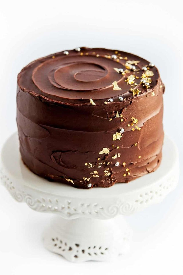 One tiered chocolate ganache cake make woth 3 layers of chocolate sponge, chocolate cream filling and decorated with gold leaf flakes.