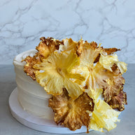 Custom cakes Honolulu by an italian pastry chef. This cake is a pineapple chiffon cake. It is made of vanilla sponge, white chocolate chantilly filling, fresh pineapple and decorated with dried pineapple flowers.