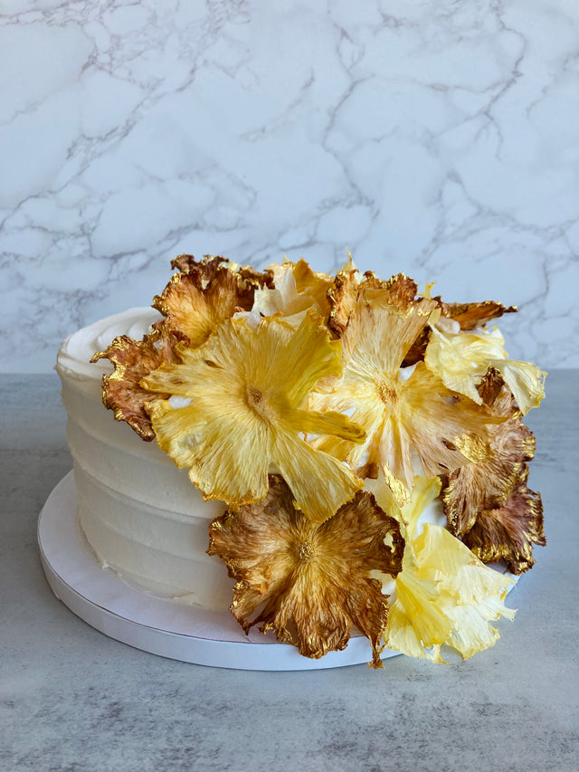 Custom cakes Honolulu by an italian pastry chef. This cake is a pineapple chiffon cake. It is made of vanilla sponge, white chocolate chantilly filling, fresh pineapple and decorated with dried pineapple flowers.