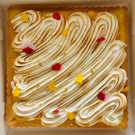 This is a lemon meringue shortbread tart. It is made with lemon-vanilla shortbread, has a lemon curd filling, and has a torched Italian meringue top layer. It is decorated with edible flowers and gold leaf flakes. 
