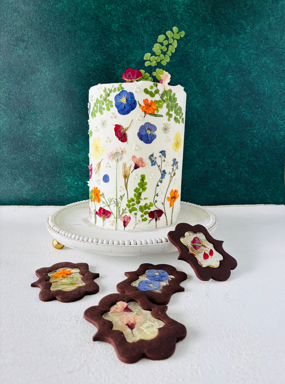 One tier white round cake. The cake is decorated with beautiful pressed flowers.