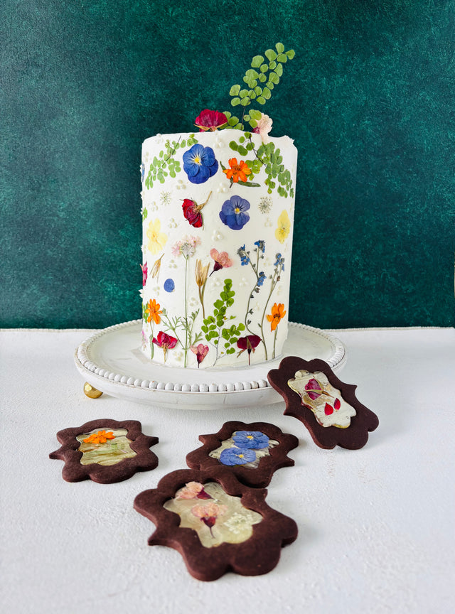 One tier white round cake. The cake is decorated with beautiful pressed flowers.