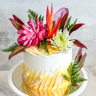 Custom Cakes for Every Occasion. Honolulu custom cakes. This round, one-tier cake is made with vanilla sponge, lemon filling, and Swiss buttercream frosting. It is decorated with fresh Hawaiian flowers.